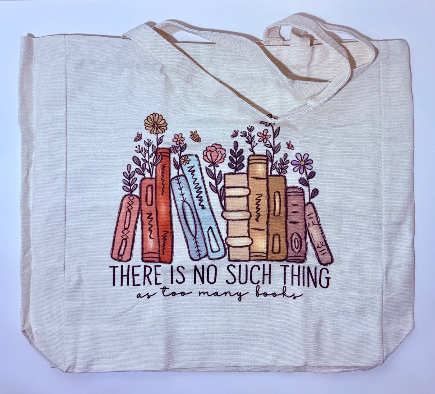 Tote bag with book and flower design and text on a light blue background