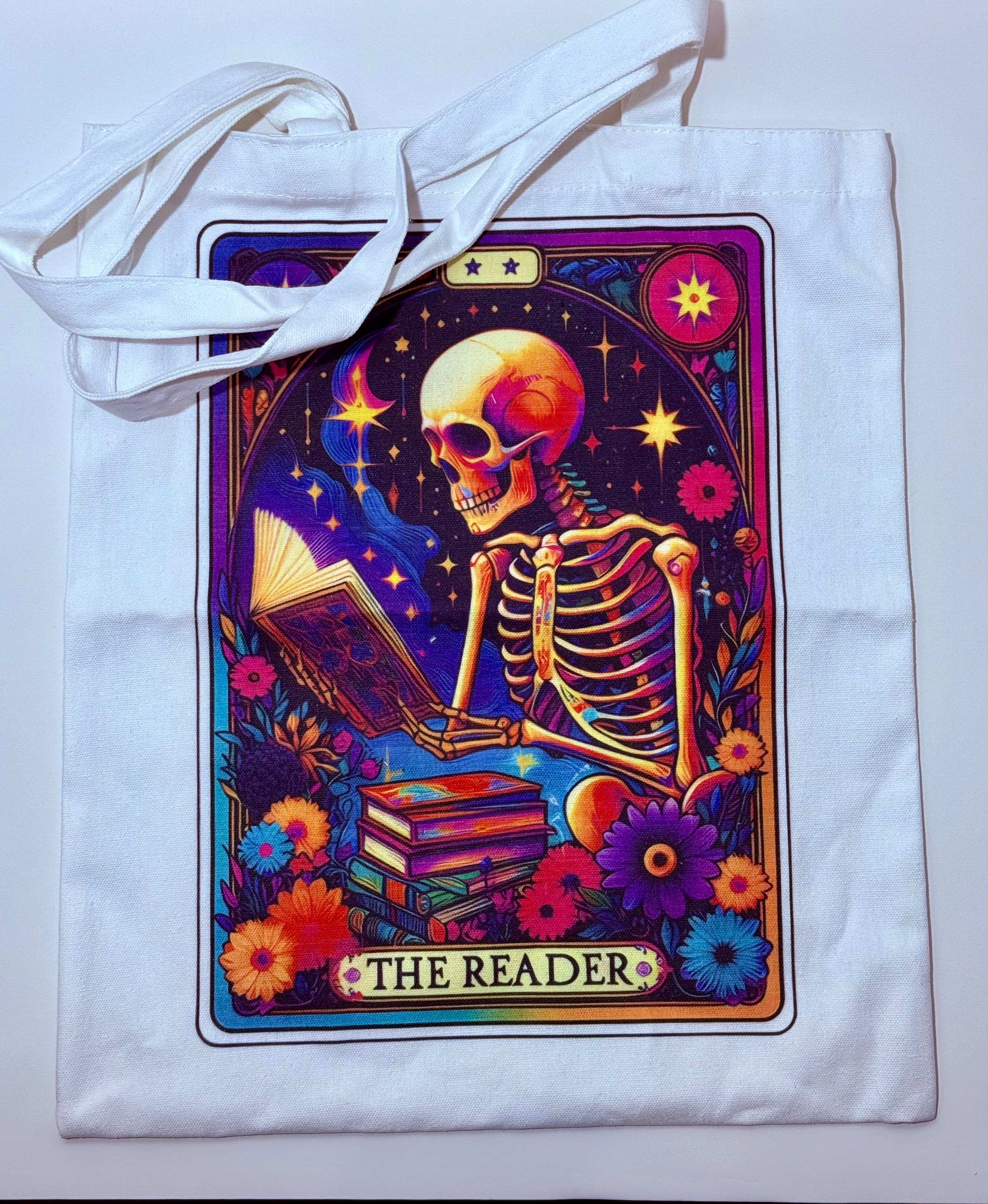 Tote bag with a colorful skeleton design labeled 'The Reader' on a white background